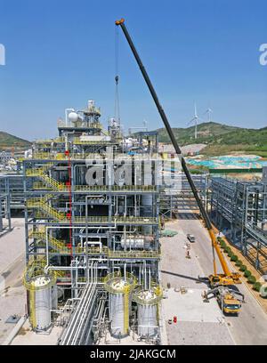 YANTAI, CHINA - MAY 31, 2022 - Cranes are hoisting chemical equipment at the Yantai Chemical Industrial Park in Yantai Development Zone, East China's Stock Photo