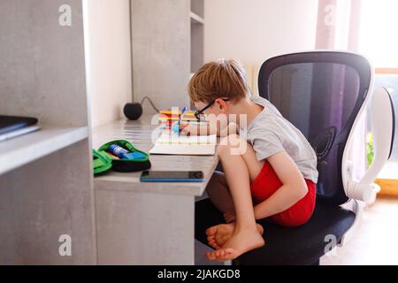 School DAYS. Random kin doing his homework Stock Photo