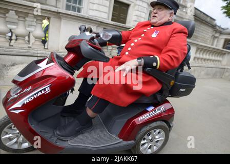 London, England, UK. Chelsea Pensioner using a mobility scooter in Whitehall, Westminster Stock Photo