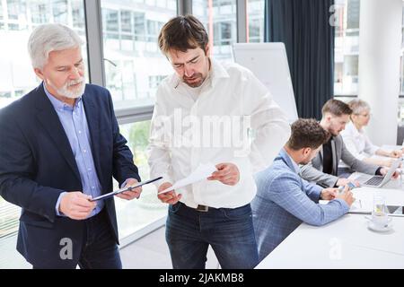 Two businessmen checking and reviewing checklist for a job or project Stock Photo
