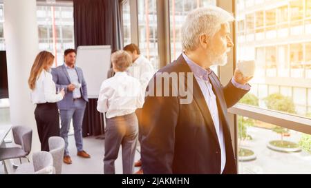 Senior businessman drinking cup of coffee on coffee break in office Stock Photo