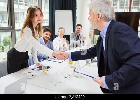 Businessman and businesswoman making handshake after successful business team meeting in office Stock Photo