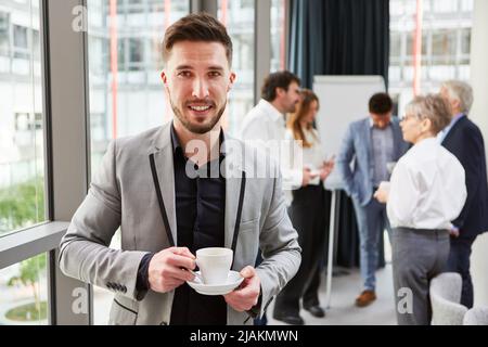 Young businessman talking on the smartphone during a coffee break in the office Stock Photo