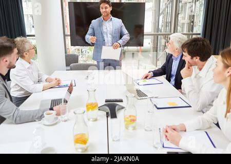 Young business man as a speaker in a meeting or workshop for further education Stock Photo