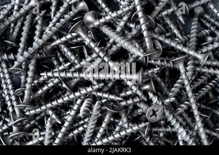 Self-tapping screw for wood made of black metal background texture. Macro shot self-tapping screw pattern Stock Photo