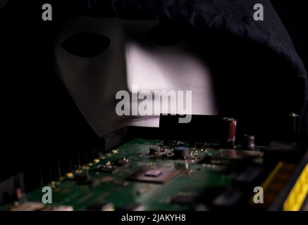 electronic circuit board with processor in the hands of a masked man Stock Photo
