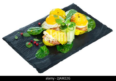 Close up of mini burgers from quail eggs with baked potatoes at plate with greens Stock Photo
