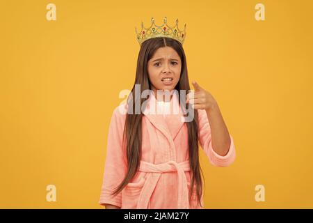 selfishness and egoism. oops. confused egocentric teen girl in crown pointing finger on camera Stock Photo