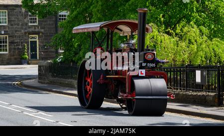 Red black stationary heavy steam-powered vehicle parked at roadside (L-plate & reg number on front) - Burley-in-Wharfedale, West Yorkshire England UK. Stock Photo