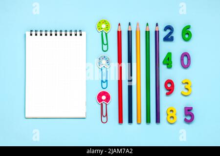 Frame from school and office supplies Paper clips, pens, felt-tip pens, sharpener, notepad, stapler isolated on blue background Flat lay Top view Back Stock Photo