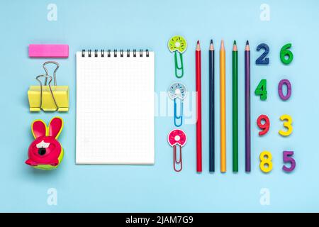 Frame from school and office supplies Paper clips, pens, felt-tip pens, sharpener, notepad, stapler isolated on blue background Flat lay Top view Back Stock Photo