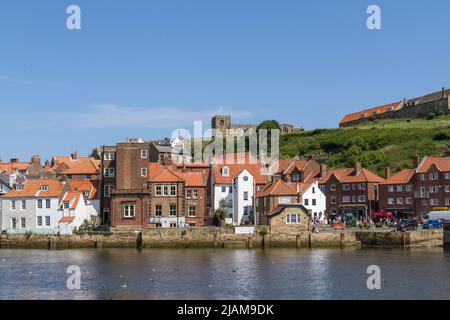 View across the River Esk and Whitby Harbour towards the Captain Cook Memorial Museum and Whitby Abbey in Whitby, North Yorkshire, England. Stock Photo