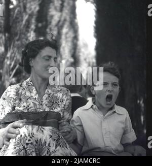 1950s, historical, a mother sitting outside with her son, who has his mouth open, excited at what he is seeing infront of him, England, UK. Stock Photo