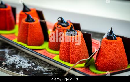 Small cone-shaped velveteen cakes decorated with chocolate paste Stock Photo