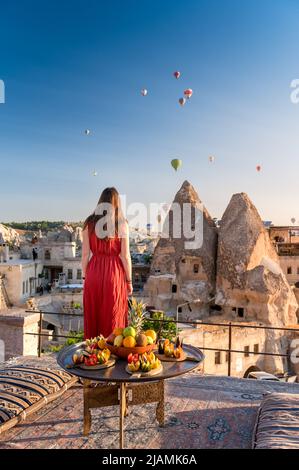 girl looking at hot air balloons in sky over Cappadocia Stock Photo