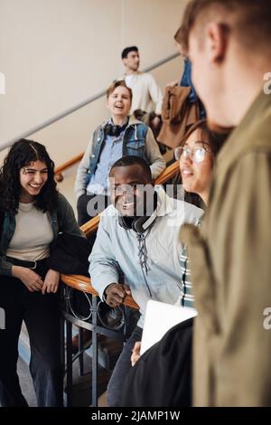Happy young multiracial students enjoying at staircase in university Stock Photo