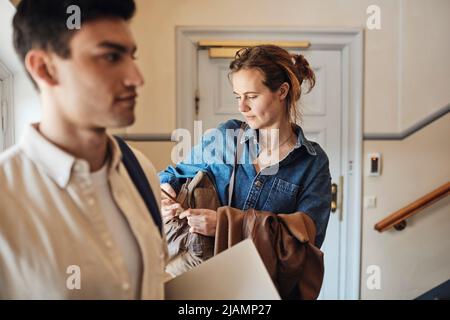 Female student using smart phone standing by male friend at university Stock Photo