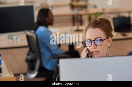 Businesswoman working talking on the phone at her office desk Stock Photo