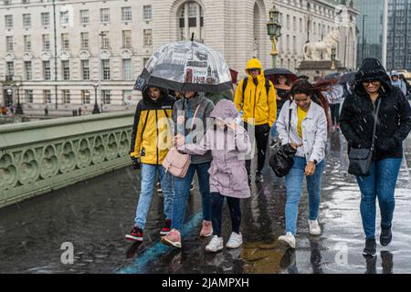 London UK, 31 May 2022. Pedestrians are caught in heavy downpours on Westminster Bridge ahead of the platinum jubilee  celebrations which start 2-5 June to mark Queen Elizabeth II accession to the throne in 1952. Credit. amer ghazzal/Alamy Live News Stock Photo