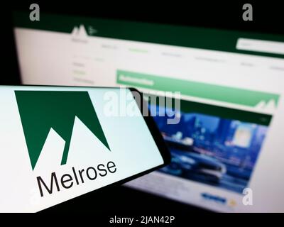 Mobile phone with logo of British company Melrose Industries plc on screen in front of business website. Focus on center of phone display. Stock Photo