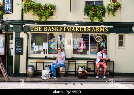 Two men relaxing on street tables outside the popular pub The Basketmakers Arms in Brighton's North Laine. Stock Photo