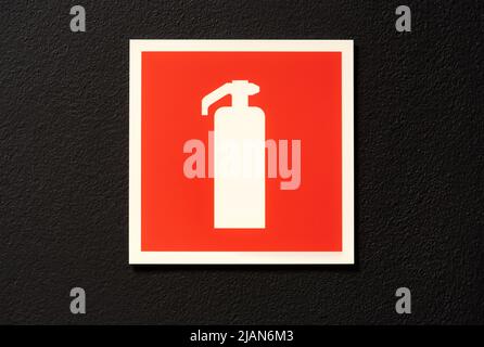 Simple fire extinguister symbol red sign, square plate, sticker on the wall, front view, frontal shot. Object closeup, nobody, fire prevention, emerge Stock Photo
