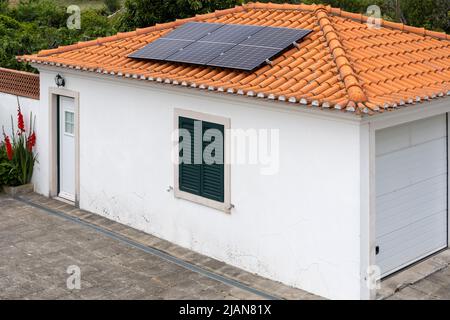 Three photovoltaic solar panels on the roof of a garage Stock Photo