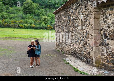 A couple of women looking at the mobile in a town Stock Photo