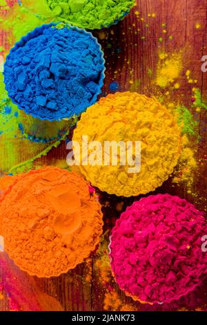 top view of colorful traditional holi powder in bowls on wood Stock Photo