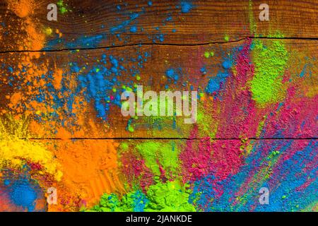 Abstract colorful Happy Holi background. Color vibrant powder on wood. Dust colored splash texture. Flat lay holi paint decoration Stock Photo