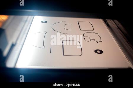 Powder 3D printer printing models from white powder polyamide close-up. Black outlines of objects are formed on white surface under action of thermal print head. New modern 3D printing technology Stock Photo