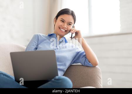 Cheerful korean lady freelancer working from home Stock Photo