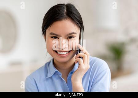 Happy attractive chinese woman having phone conversation Stock Photo
