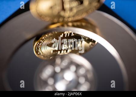 Gold bitcoin reflecting on hard drive platter, closeup of btc and hard disk. Concept of blockchain storage on hard disk Stock Photo