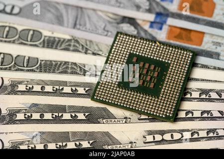 CPU processor on dollar bills. Transistors on central processing unit and pins for connection. Cost of technology concept Stock Photo