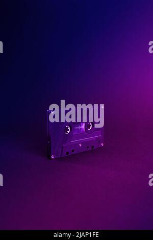 Audio cassette close up, isolated on purple and blue background. Analog Audio Tape. Audio K7 Tape isolated and center on purple degradee background. Stock Photo