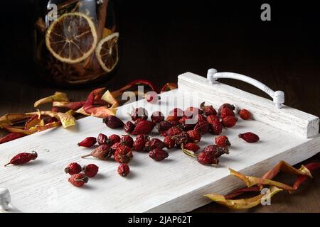 Dried rose hips, apples and orange slices on a white painted tray provence Stock Photo