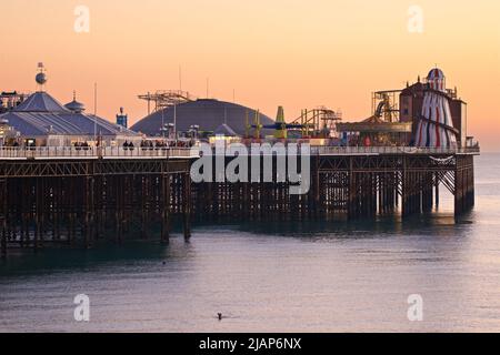 Brighton's Palace Pier, or BRIGHTON PIER.  Brighton & Hove, Sussex, England, UK. Photographed at dusk with the helter skelter and amusements. Stock Photo