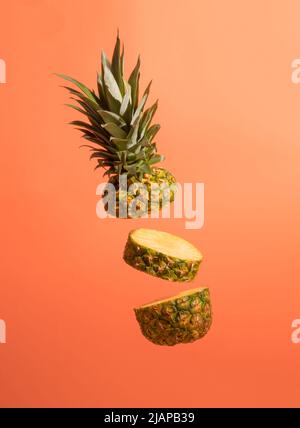 Sliced juicy pineapple on pastel orange background. Minimal fruit concept. Stock Photo