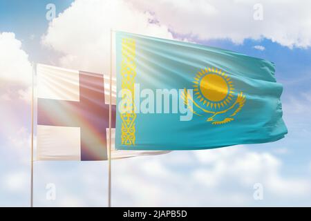 Sunny blue sky and flags of kazakhstan and finland Stock Photo