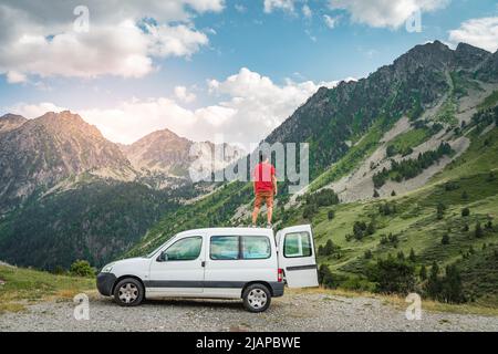 Young man enjoying nature on top of his camper van. Stock Photo