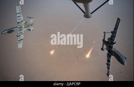 U.S. Air Force A-10 Thunderbolt IIs fire flares while breaking away after aerial re-fueling from a KC-135 Stratotanker assigned to the 340th Expeditionary Aerial Refueling Squadron out of Kandahar Airfield, Afghanistan, Aug. 15, 2019. The A-10 provides coalition forces with close air support and precision strike capacity for targeting Taliban revenue sources.  Optimised version of a  USAF photo. Credit US Navy / K. Bowes Stock Photo