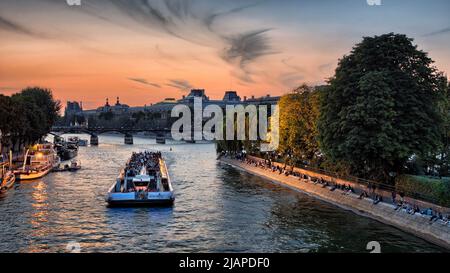 Bateaux Mouches on the Seine, Paris, France. Tour boats cruising up and down the Seine, illuminating landmarks with powerful floodights. Image taken from the Pont Neuf showing the Galerie du Vert Galant at the tip of the ële de la CitŽ. Stock Photo