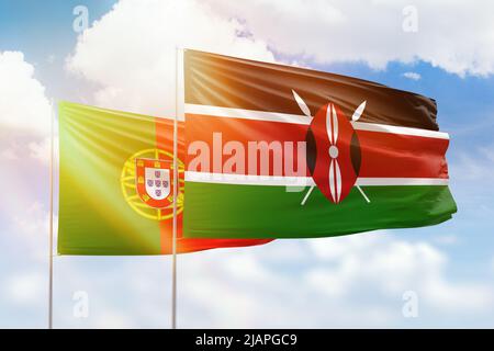 Sunny blue sky and flags of kenya and portugal Stock Photo