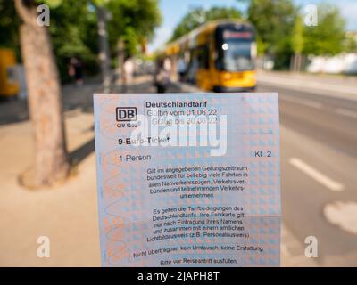 9 Euro Ticket at a cable car station for public transport. Holding the ticket and look at it. The 'Deutschlandtarif' is part of the 'Entlastungspaket' Stock Photo