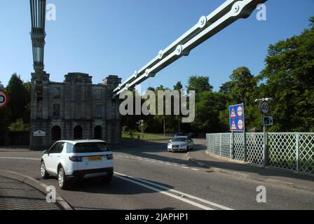 The Menai Suspension Bridge, designed by Thomas Telford, looking across Menai Strait towards the island of Anglesey, Wales, UK. Stock Photo