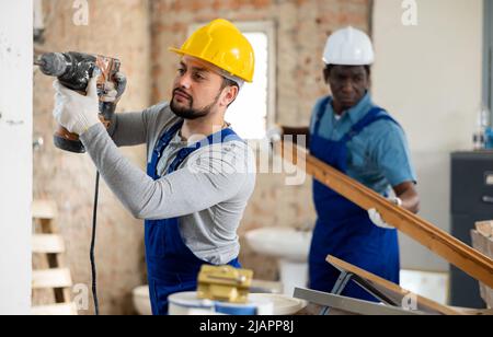 Man builder using electric hammer in construction site Stock Photo