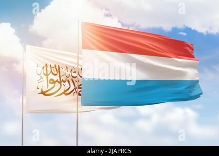 Sunny blue sky and flags of luxembourg and afghanistan Stock Photo