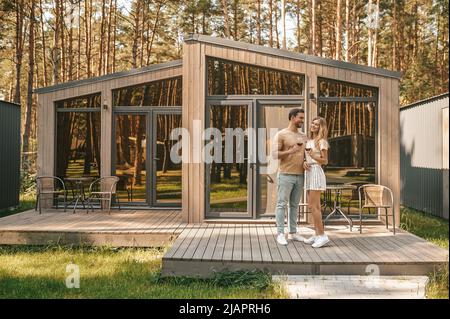 Couple with glasses of red wine standing on the porch Stock Photo