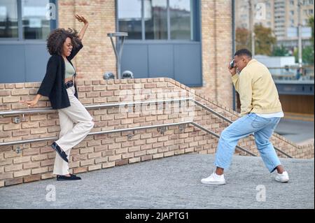 Guy photographing posing girl on street Stock Photo